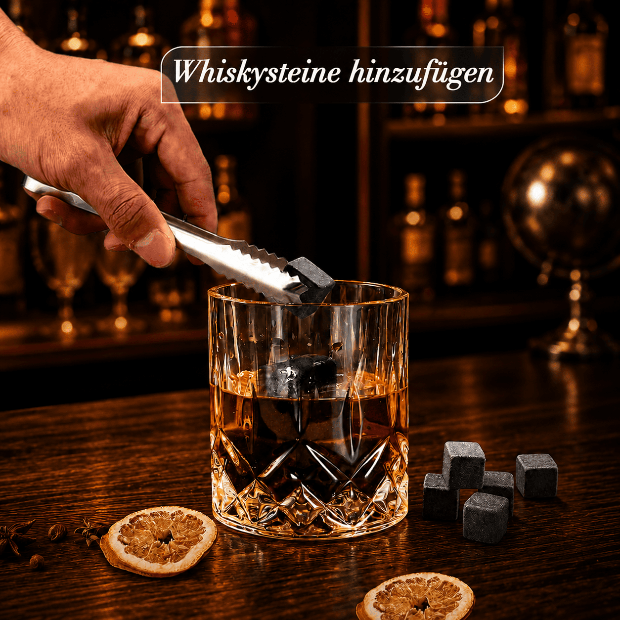 Natürliche Whiskysteine aus Granit werden mit einer Edelstahlzange in ein Kristallglas mit Scotch gegeben